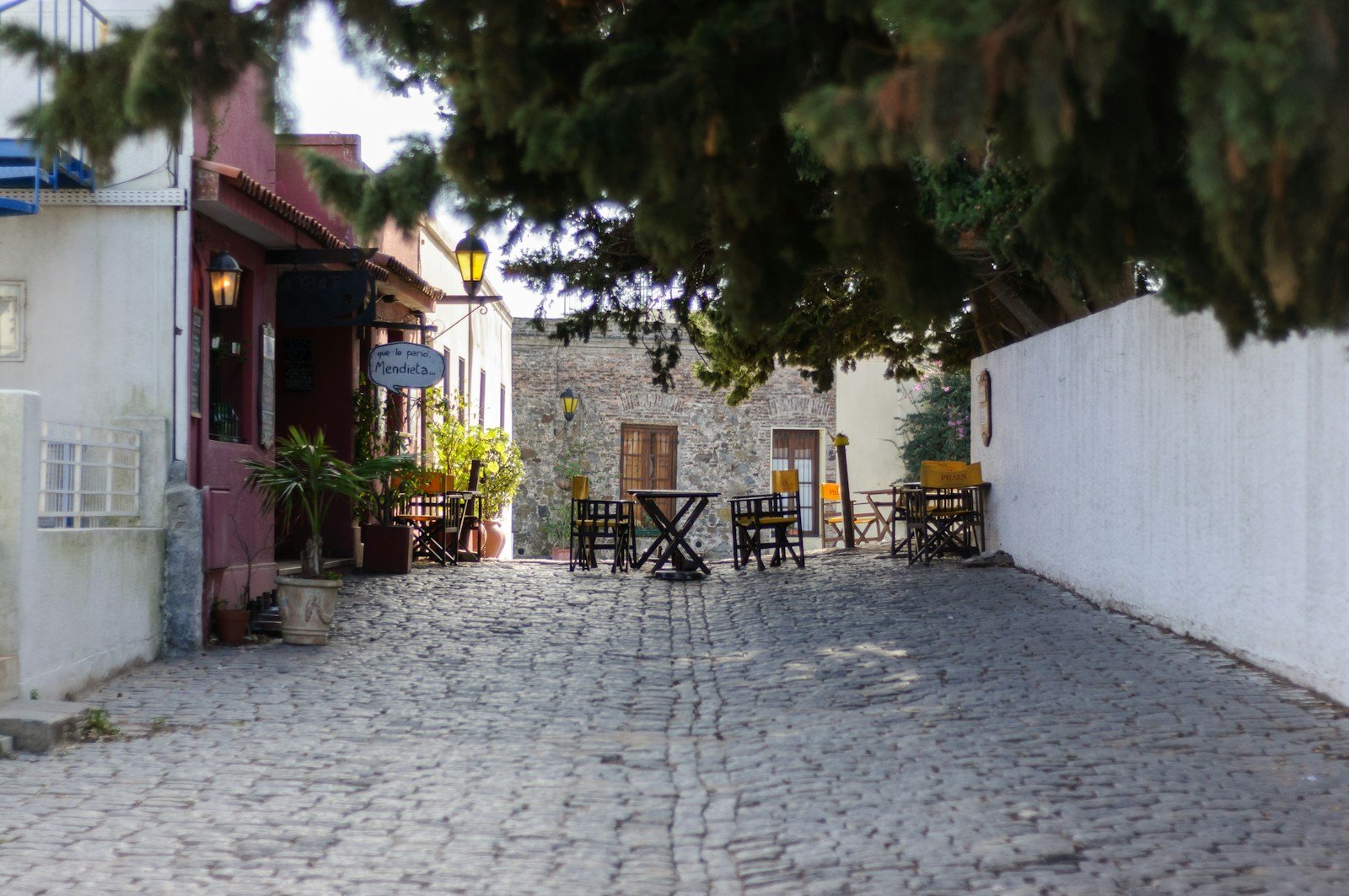 a cobblestone street lined with tables and chairs