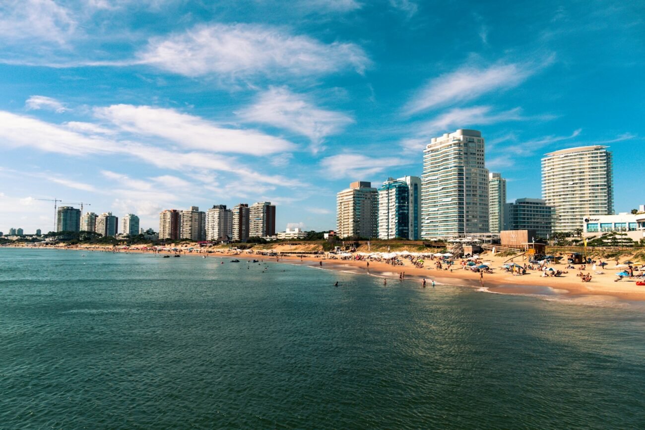 high rise buildings near sea under blue sky and white clouds during daytime